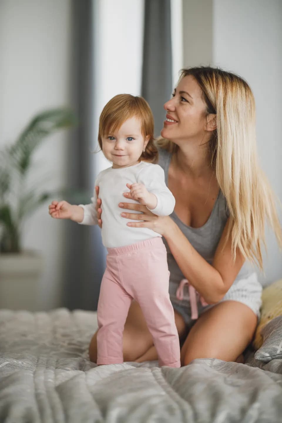 Une mère aide sa fille à se tenir debout