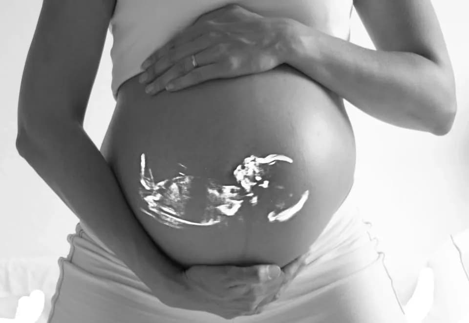 Mains sur un ventre de femme enceinte